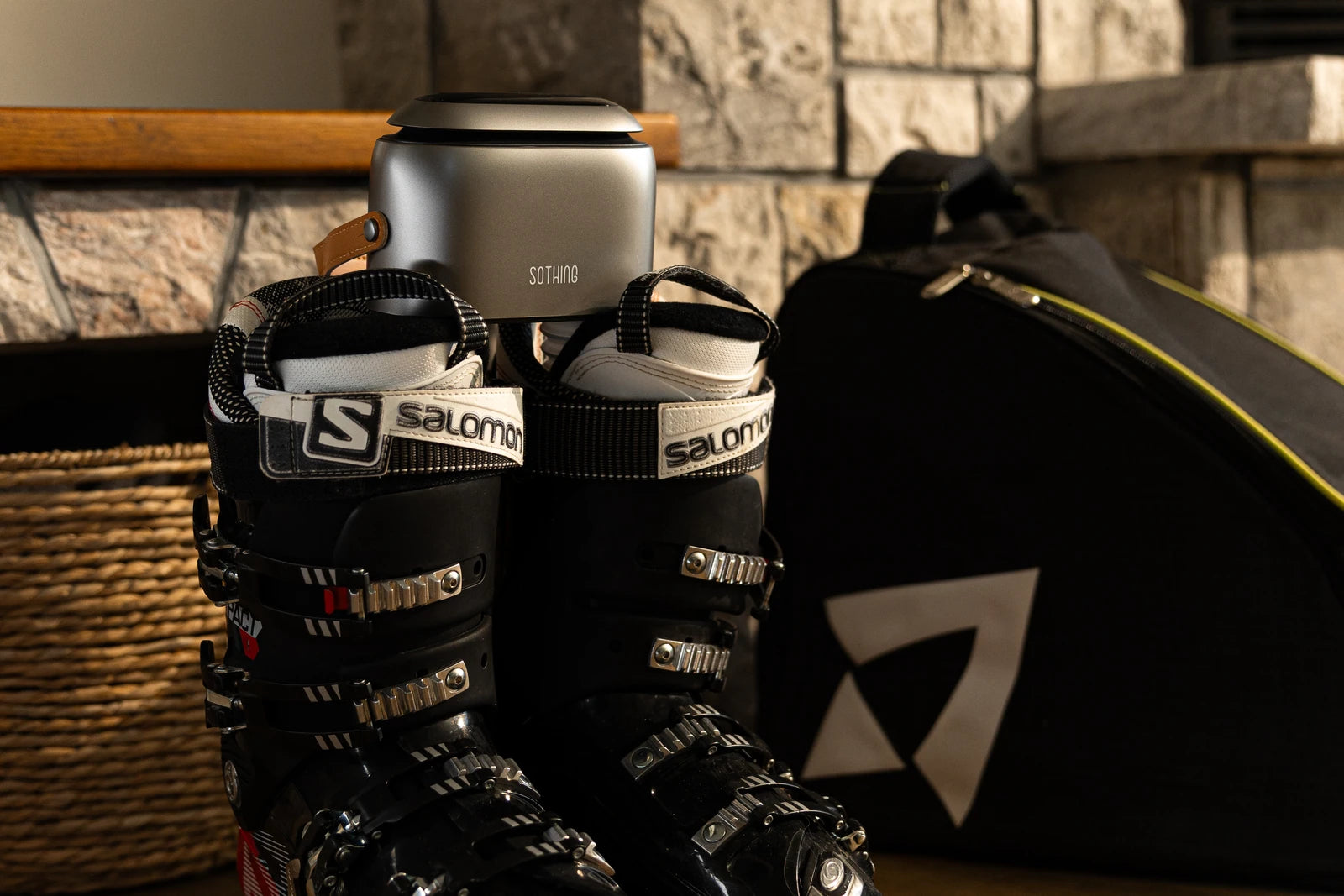 Original SOTHING Ultra Grey photograph with black Salomon ski boots beside a stone wall