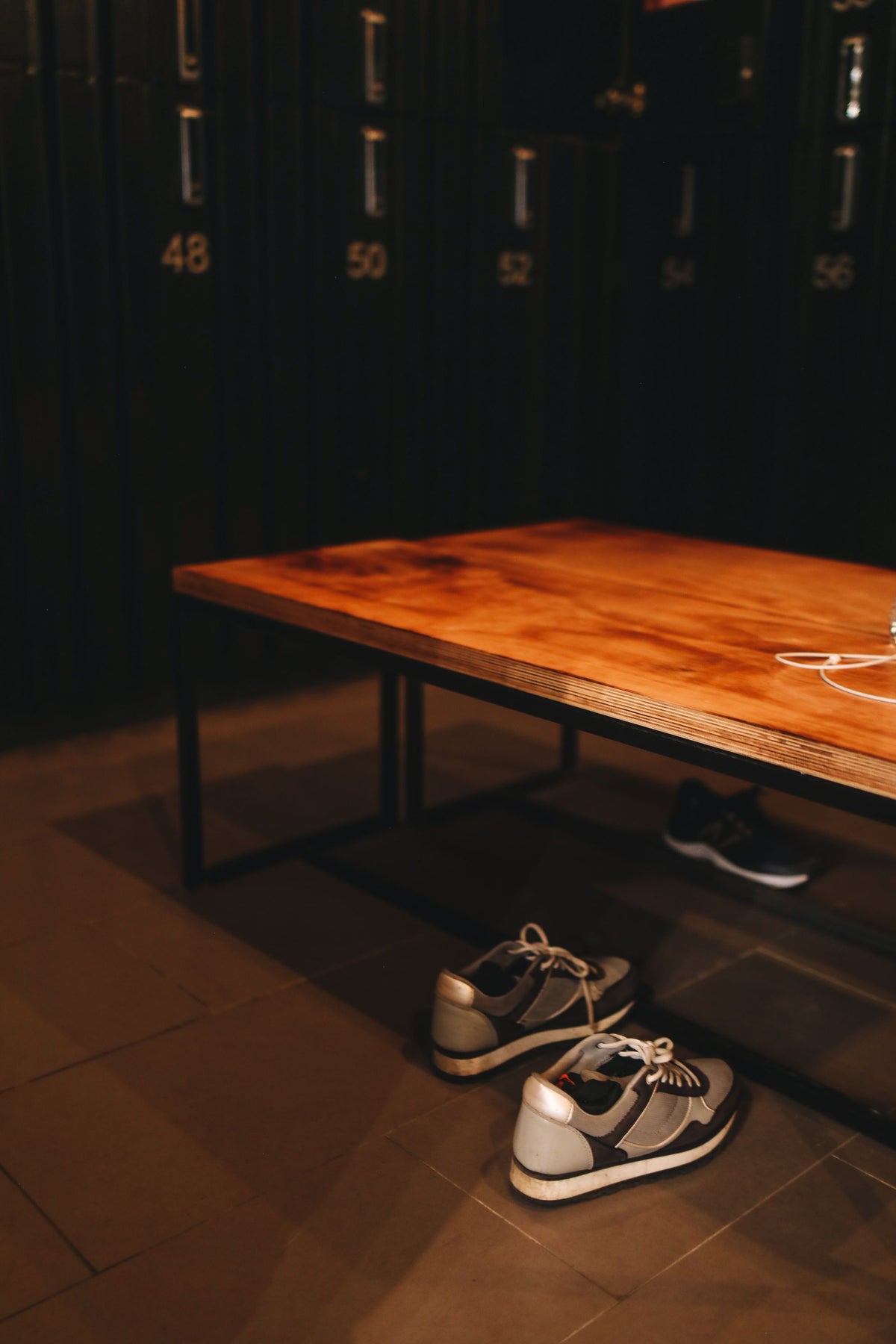 Trainers beneath a wooden locker-room bench