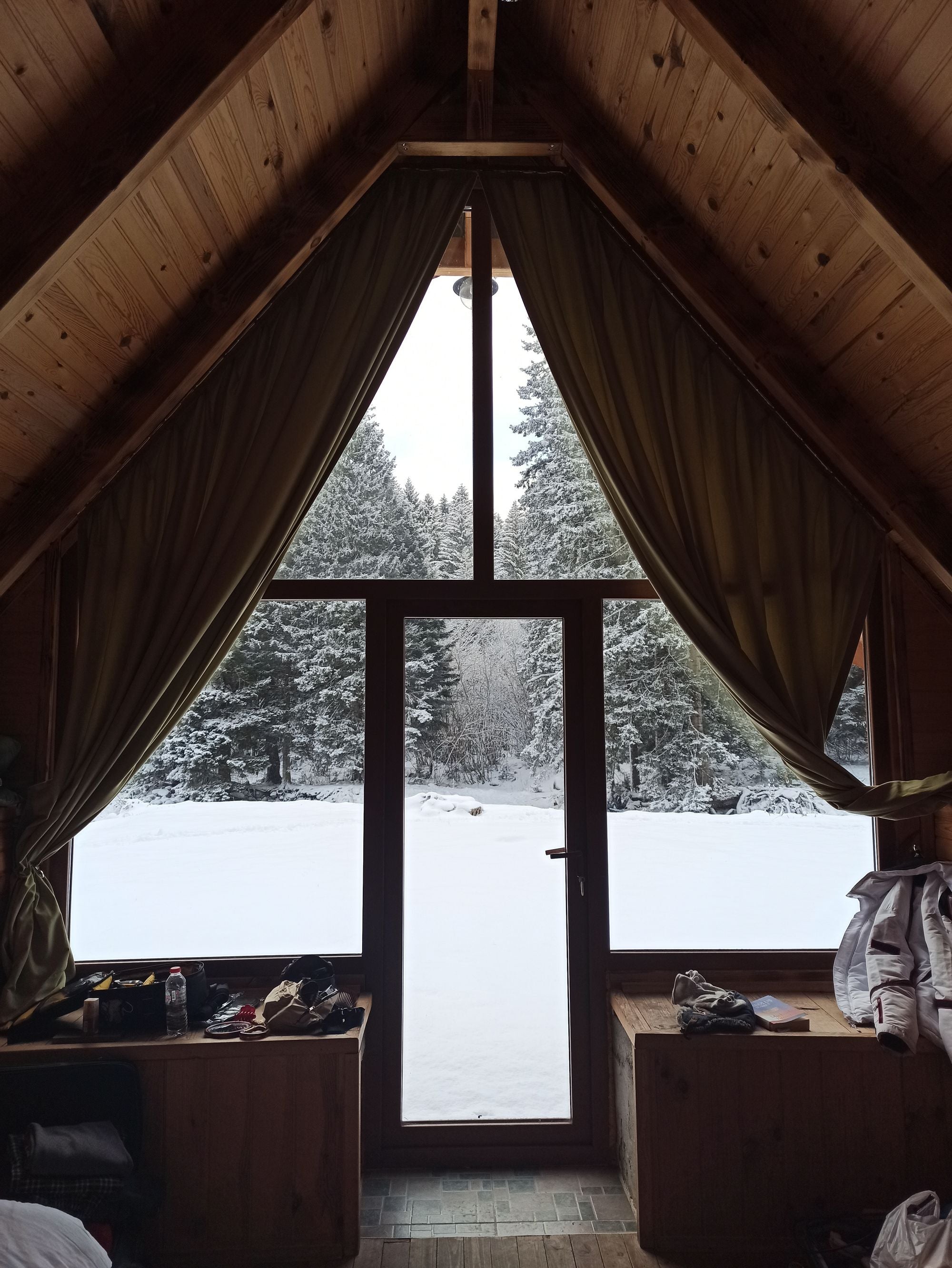 Refugio de esquí de madera con vistas a un bosque nevado